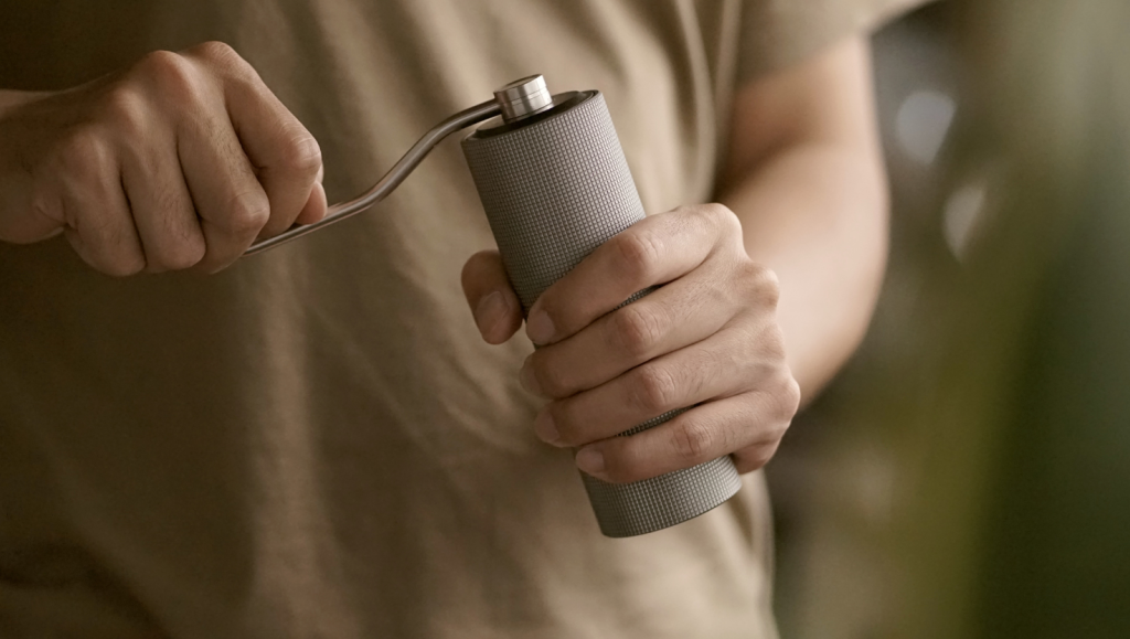 Mann dreht Kaffeemühle