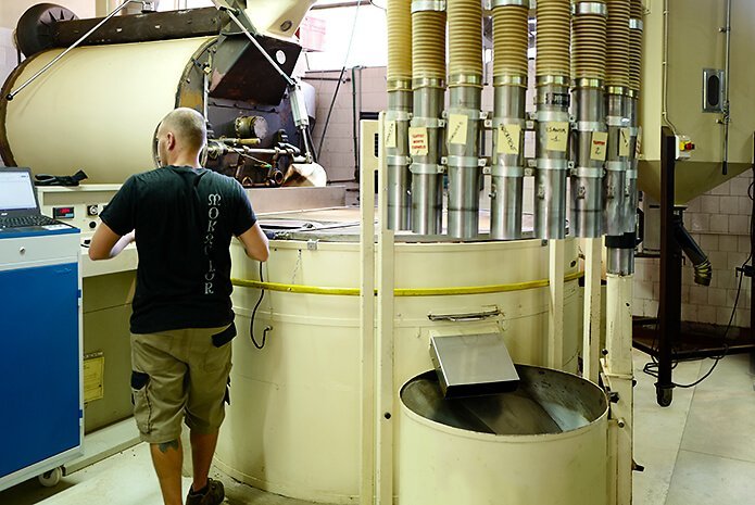 mann steht bei röstmaschine